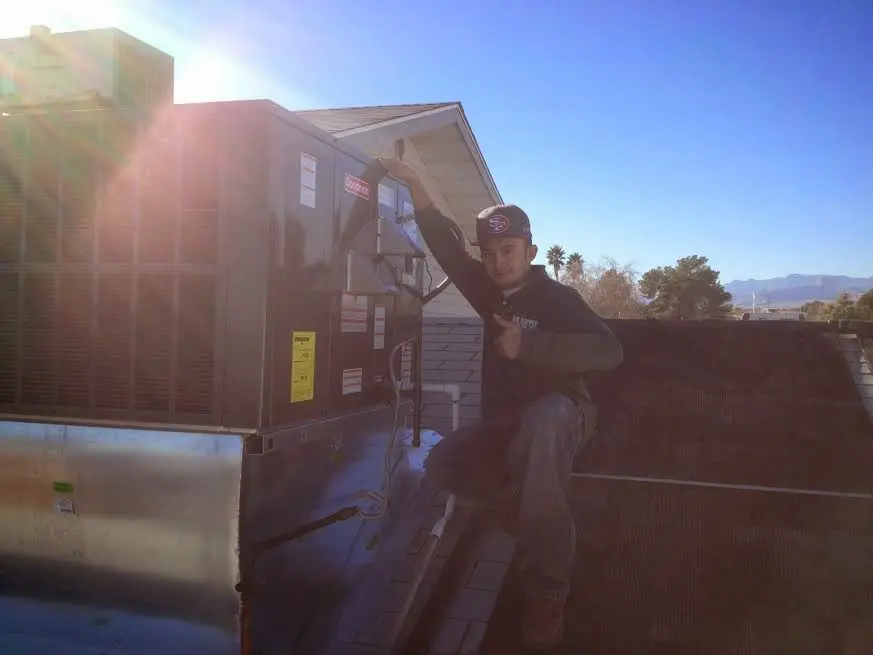 HVAC technician performing Boiler Repair on a rooftop unit in Indianola